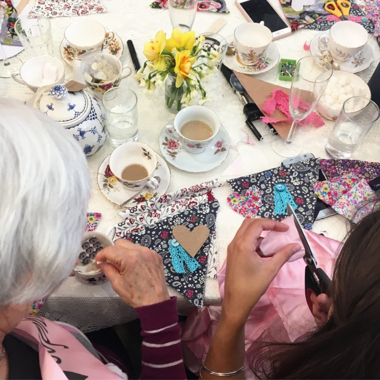 ladies sewing fabric on a bunting workshop with afternoon tea