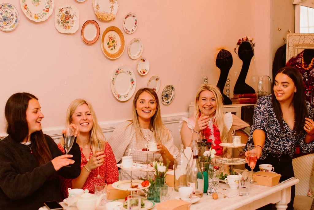 ladies smiling as they toast at an afternoon tea party in Ashwell & Co