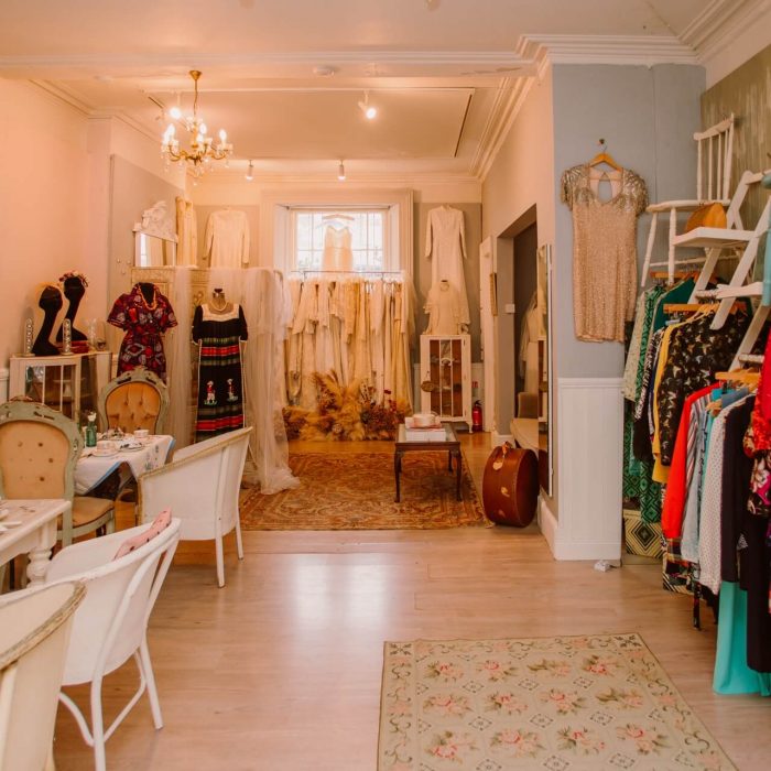 Interior of Ashwell & Co, with vintage tea room, vintage bridal dresses and vintage clothes hanging from vintage chairs