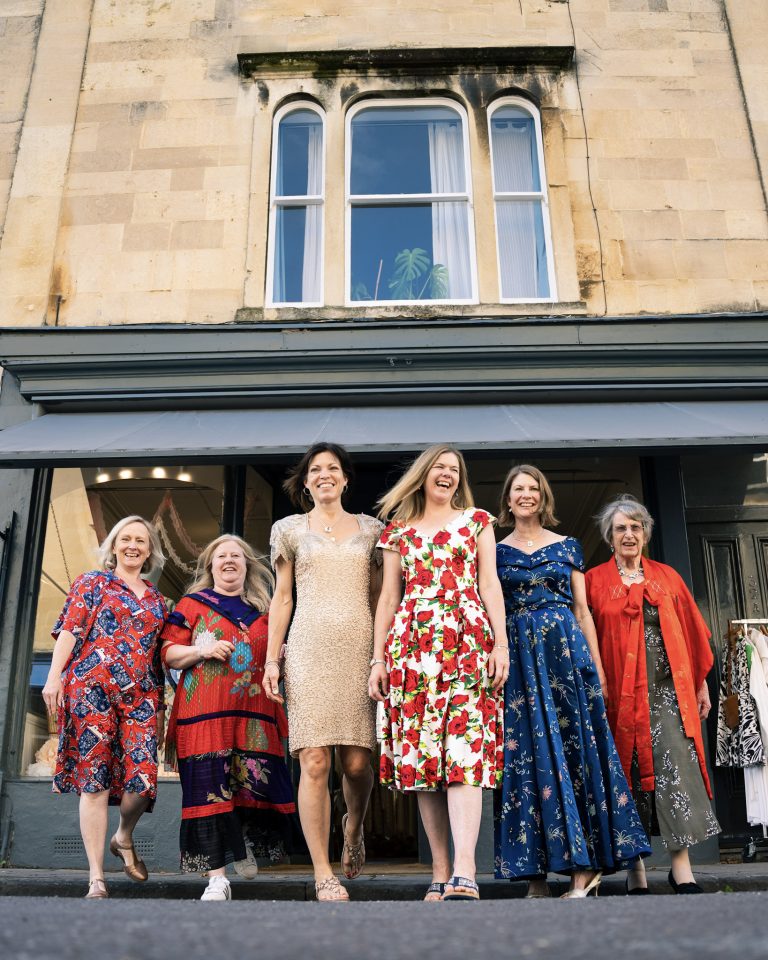 Ladies smiling in vintage dresses outside the Ashwell & Co shop