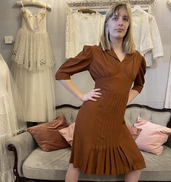 Step into a piece of fashion history with our Very Rare 1930s Rust Day Dress. Crafted with meticulous attention to detail, this exquisite garment exudes timeless elegance and sophistication. A true treasure for vintage enthusiasts and collectors alike, it's perfect for making a statement at any occasion.